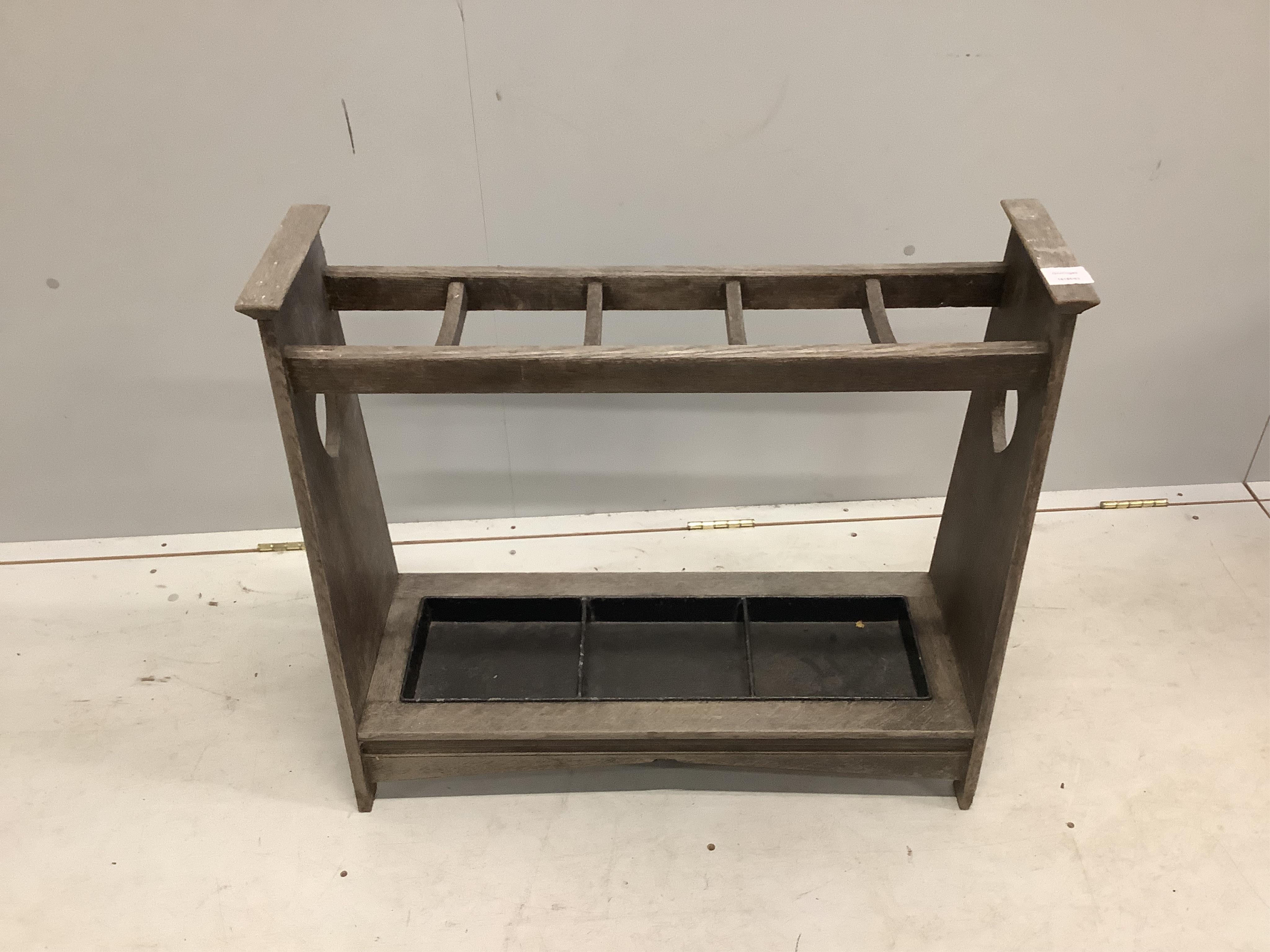 An Arts and Crafts style bleached oak five division stick stand, width 78cm, depth 30cm, height 69cm. Condition - poor to fair
